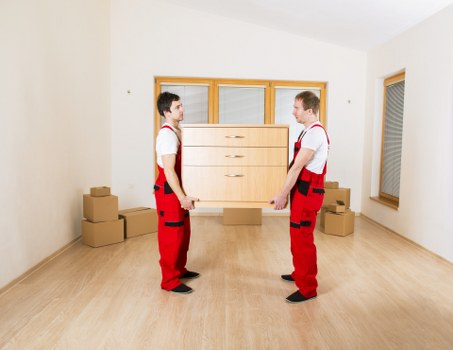 Professional movers carrying belongings down stairs in a South Kensington flat